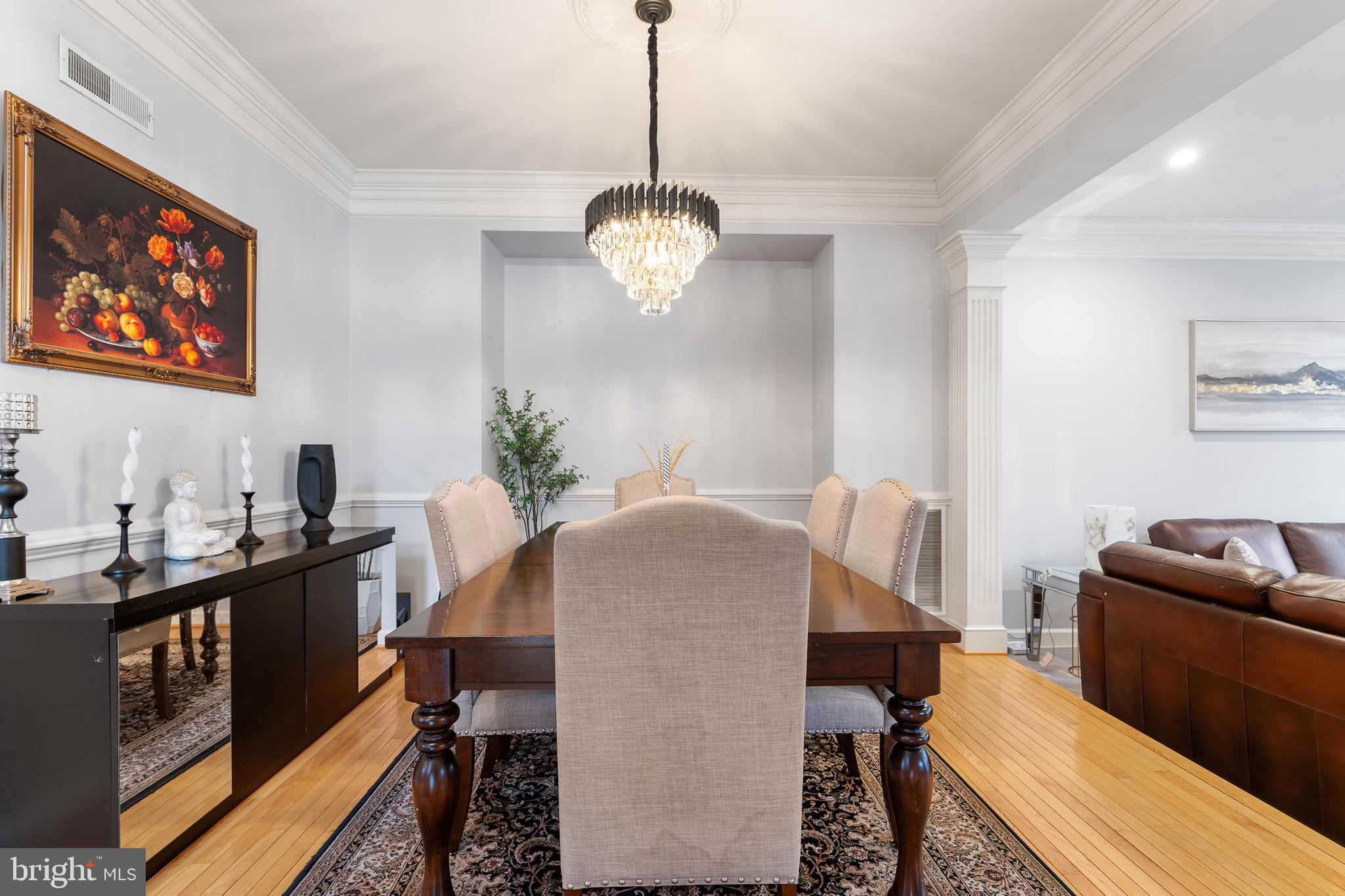 12461 Rose Path Circle Fairfax, VA 22033 - Photo 7 of 43 a dining room with wooden floor a chandelier a wooden table and chairs