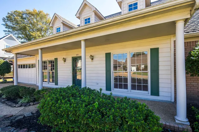 a view of a house with potted plants and a large window