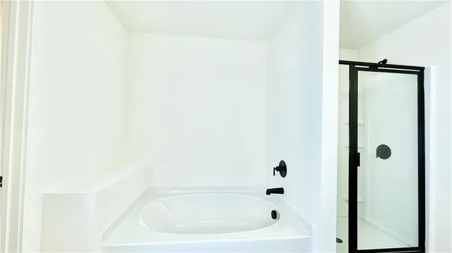 a spacious bathroom with a bathtub and a sink