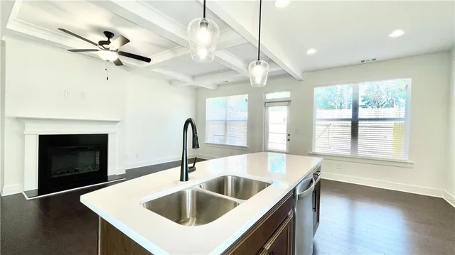 a view of entryway and kitchen with a sink wooden floor and a window
