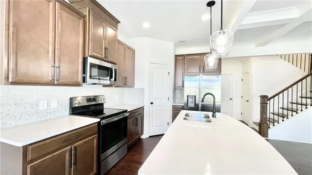 a kitchen with stainless steel appliances a stove a sink and a refrigerator