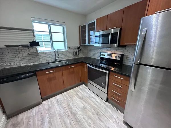 a kitchen with granite countertop a sink stove and refrigerator