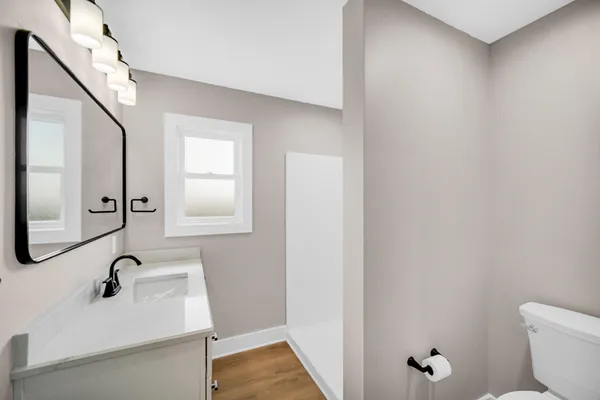 a bathroom with a sink a toilet and mirror
