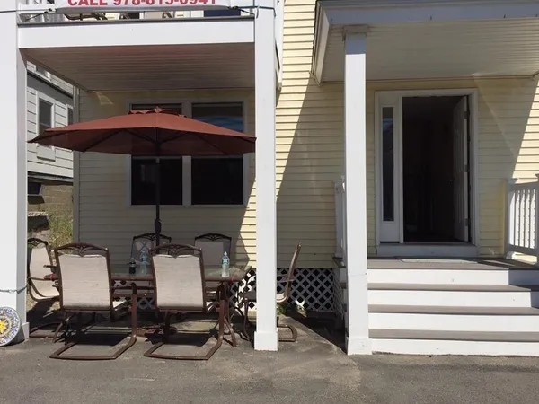 a view of a house with a small yard and potted plants