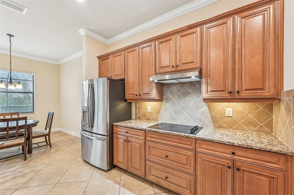 20345 Reale Circle Venice, FL 34293 - Photo 16 of 80 a kitchen with stainless steel appliances granite countertop a refrigerator sink and cabinets