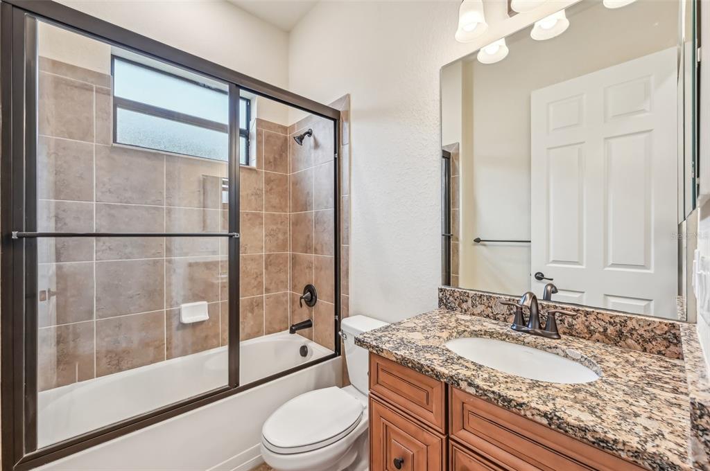 20345 Reale Circle Venice, FL 34293 - Photo 37 of 80 a bathroom with a granite countertop sink toilet mirror and shower