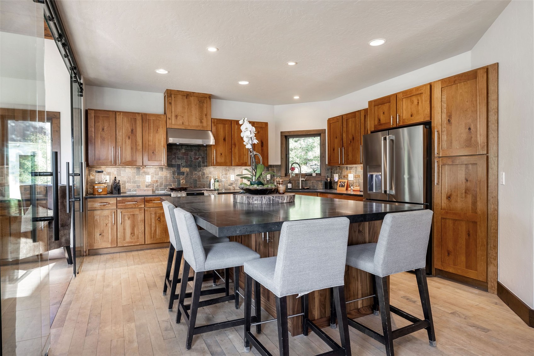 430 Giberson Road Frisco, CO 80443 - Photo 6 of 27 a kitchen with stainless steel appliances granite countertop a refrigerator a stove a kitchen island and chairs with wooden floor