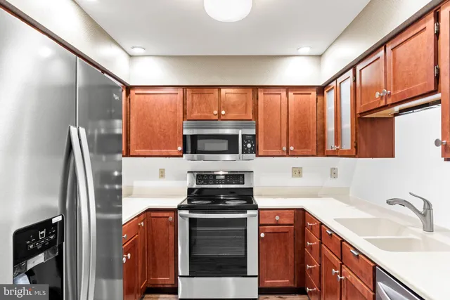 a view of an empty room with wooden floor fireplace and a window