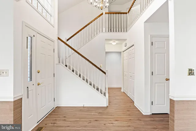 an empty room with windows fireplace and wooden floor