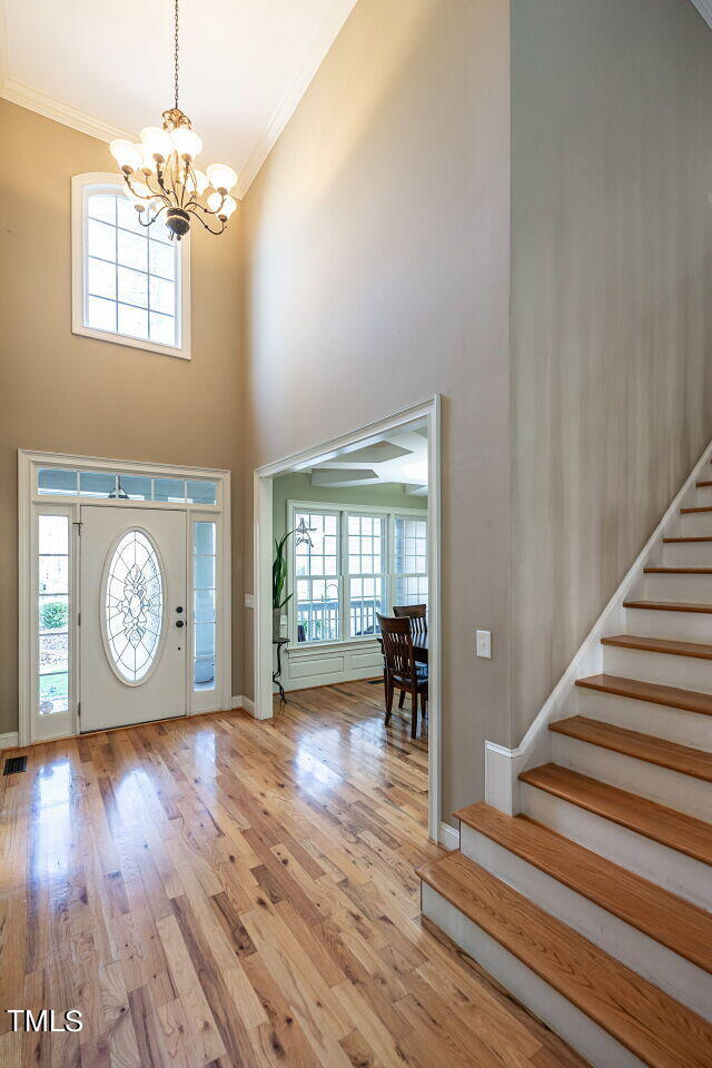 1173 Smith Creek Way Wake Forest, NC 27587 - Photo 4 of 42 an empty room with wooden floor chandelier and windows