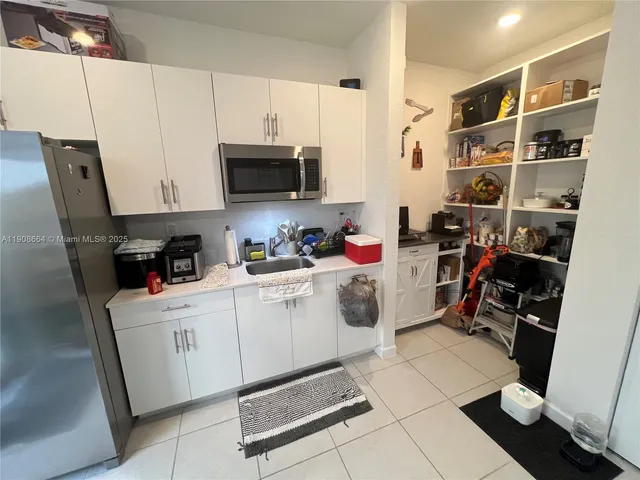 a room with a white cabinets and appliances