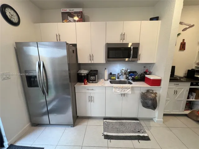 a kitchen with stainless steel appliances a refrigerator sink and microwave