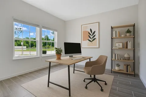 a view of a workspace with furniture and a window