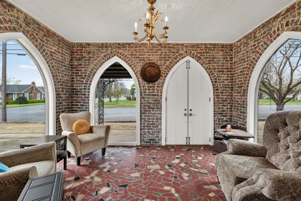a living room with couches and a fireplace with wooden floor