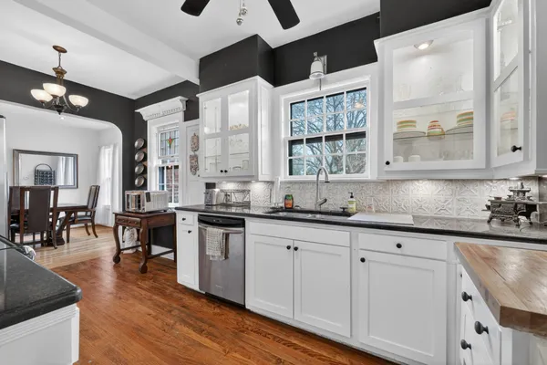 a kitchen with granite countertop a sink cabinets and wooden floor