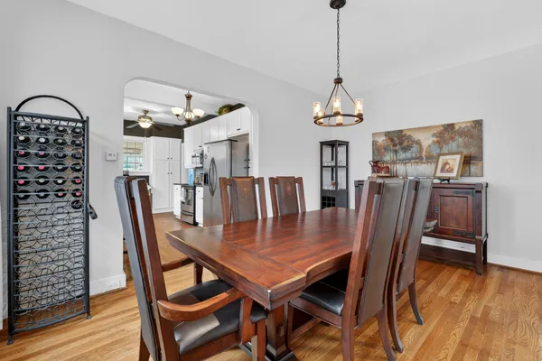 a dining room with furniture a chandelier and wooden floor