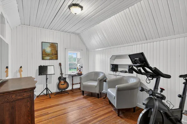 a room with furniture a flat screen tv and gym equipment