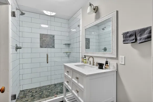 a bathroom with a sink a toilet and shower
