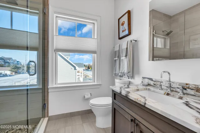 a bathroom with a granite countertop toilet sink and mirror