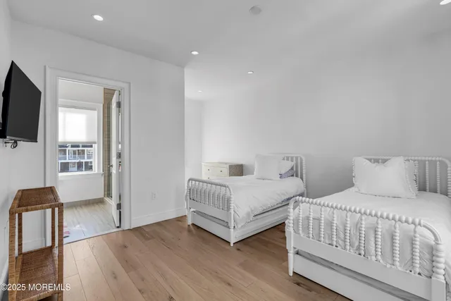 a bedroom with two beds and a flat screen tv
