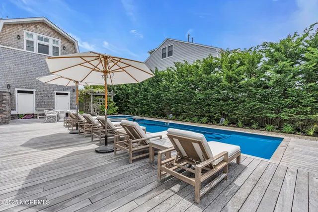 a view of a roof deck with table and chairs under an umbrella with wooden floor