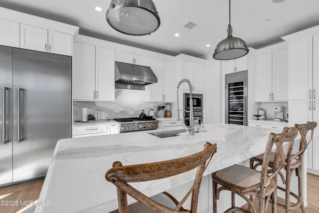 a kitchen with stainless steel appliances granite countertop a stove a sink and a refrigerator