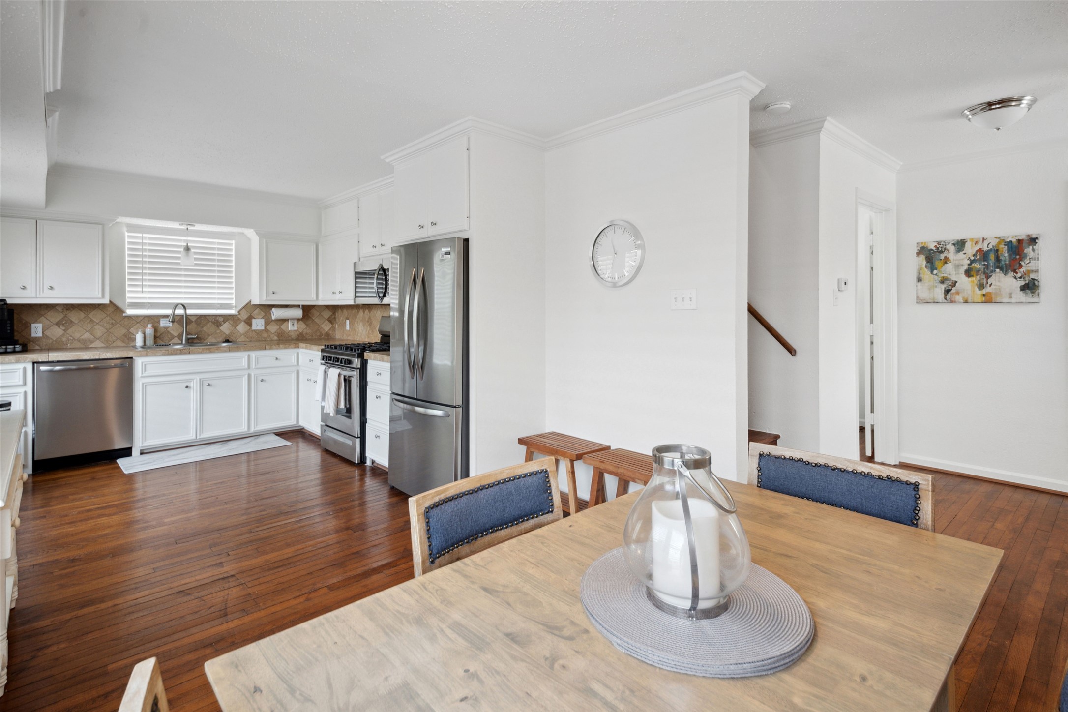 1105 Tulane Street, Unit B Houston, TX 77008 - Photo 11 of 24 a kitchen with stainless steel appliances granite countertop a refrigerator a stove top oven a dining table and chairs with wooden floor