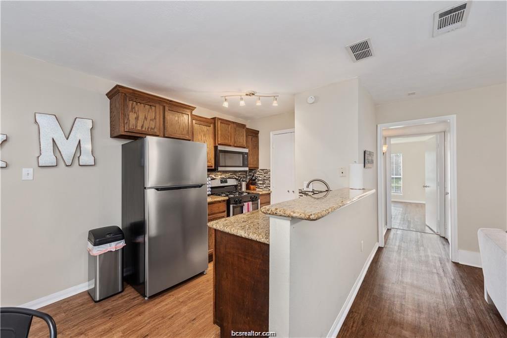 1227 Oney Hervey Drive College Station, TX 77840 - Photo 7 of 22 a kitchen with stainless steel appliances granite countertop a refrigerator and a sink