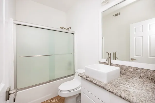 a spacious bedroom with a bed and wooden floor