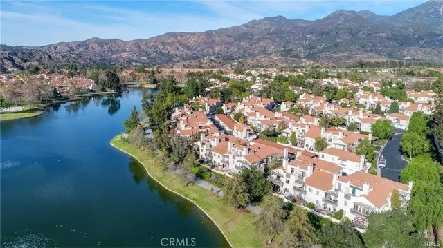 an aerial view of a house with a garden and lake view
