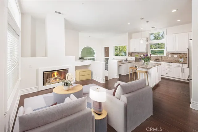 a living room with fireplace furniture and a large window