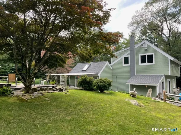 a front view of house with yard and trees