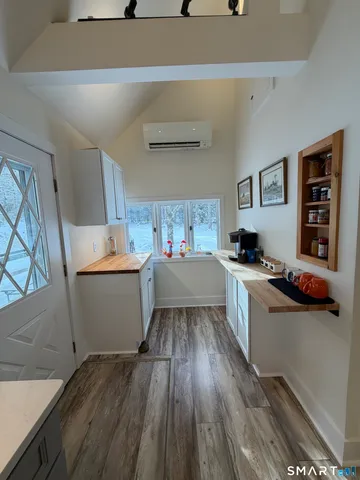 a kitchen with a wooden floor and white appliances