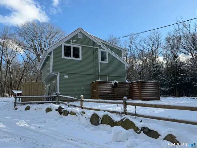 a backyard of a house with table and chairs