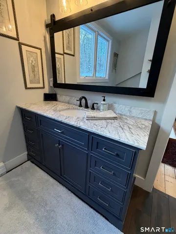 a bathroom with a granite countertop sink and a mirror