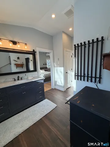 a kitchen with stainless steel appliances kitchen island granite countertop a refrigerator a stove and a sink with wooden cabinets