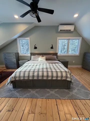 a bedroom with a bed and wooden floor