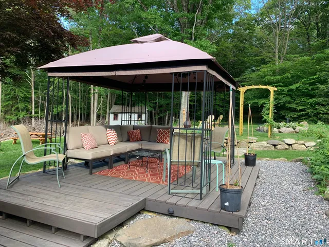 a view of a patio with table and chairs potted plants with wooden floor and fence