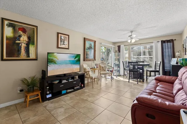 a living room with furniture a dining table and a flat screen tv with wooden floor