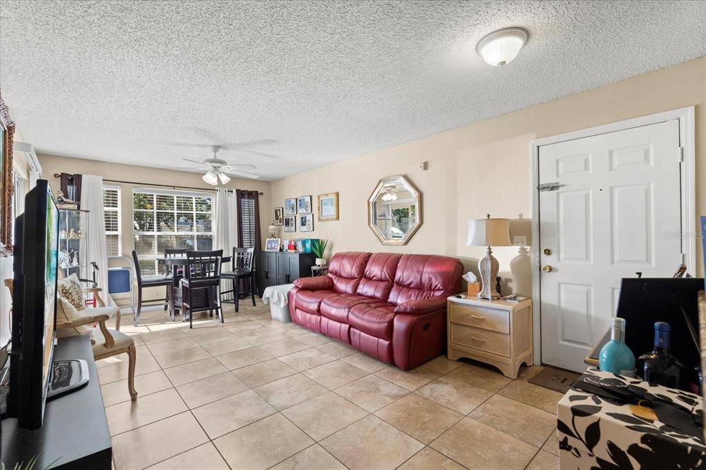 1063 South Hiawassee Road, Unit 1615 Orlando, FL 32835 - Photo 4 of 20 a living room with furniture and a flat screen tv