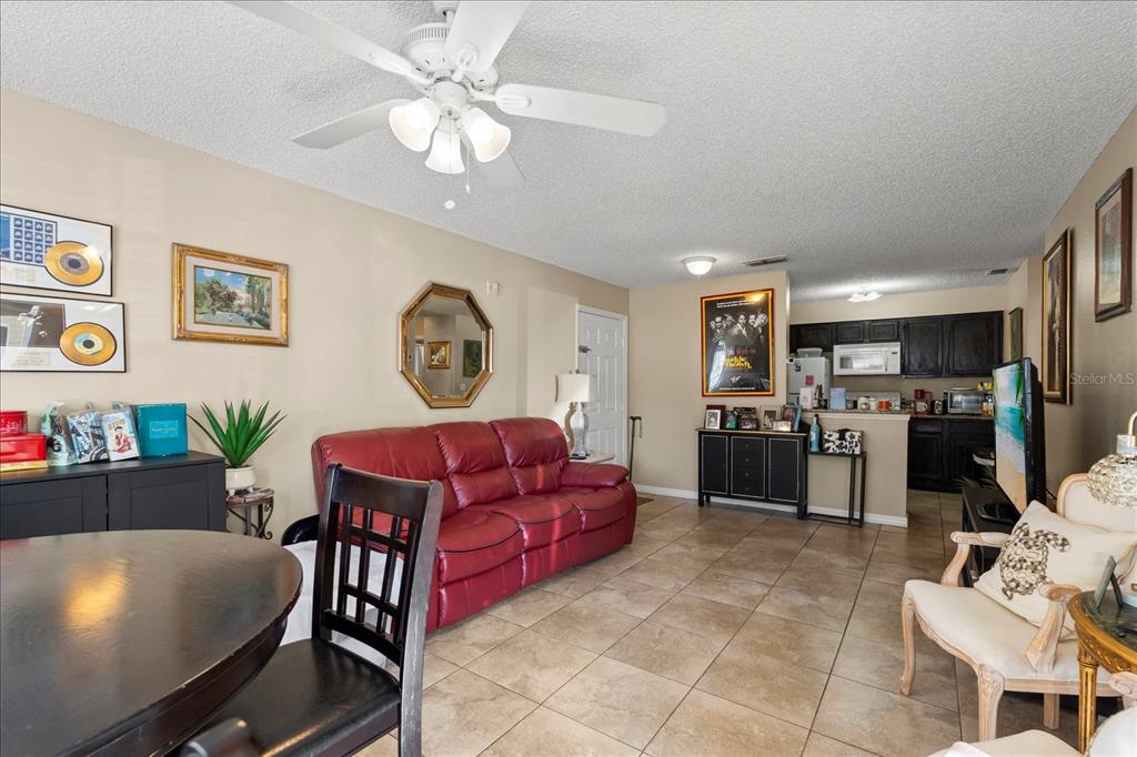 1063 South Hiawassee Road, Unit 1615 Orlando, FL 32835 - Photo 6 of 20 a living room with furniture a flat screen tv and kitchen view