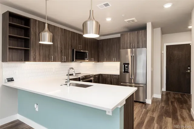 a kitchen with a sink a refrigerator and a stove