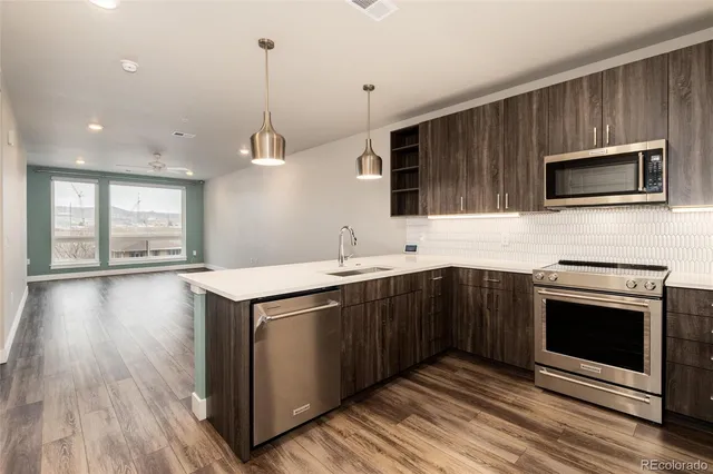 a kitchen with stainless steel appliances kitchen island granite countertop a stove a sink and a microwave