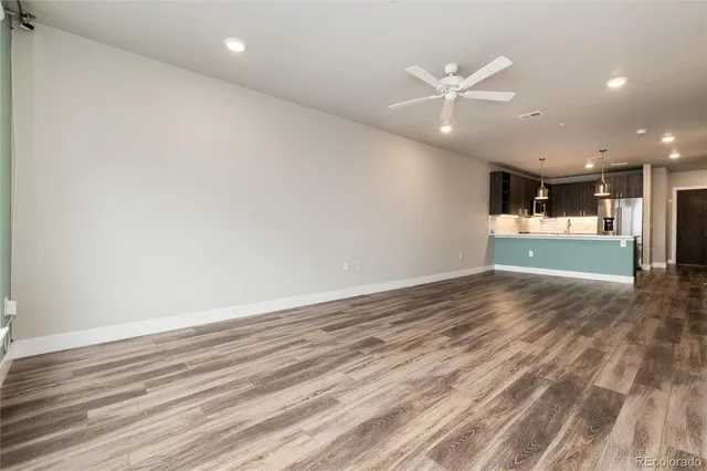 an empty room with wooden floor and natural light