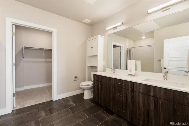 a bathroom with a double vanity sink mirror and toilet
