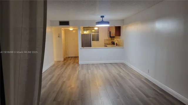a view of a hallway to kitchen with wooden floor