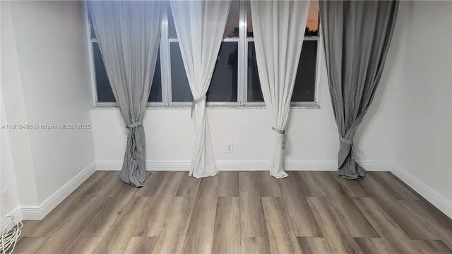 a view of a room with wooden floor