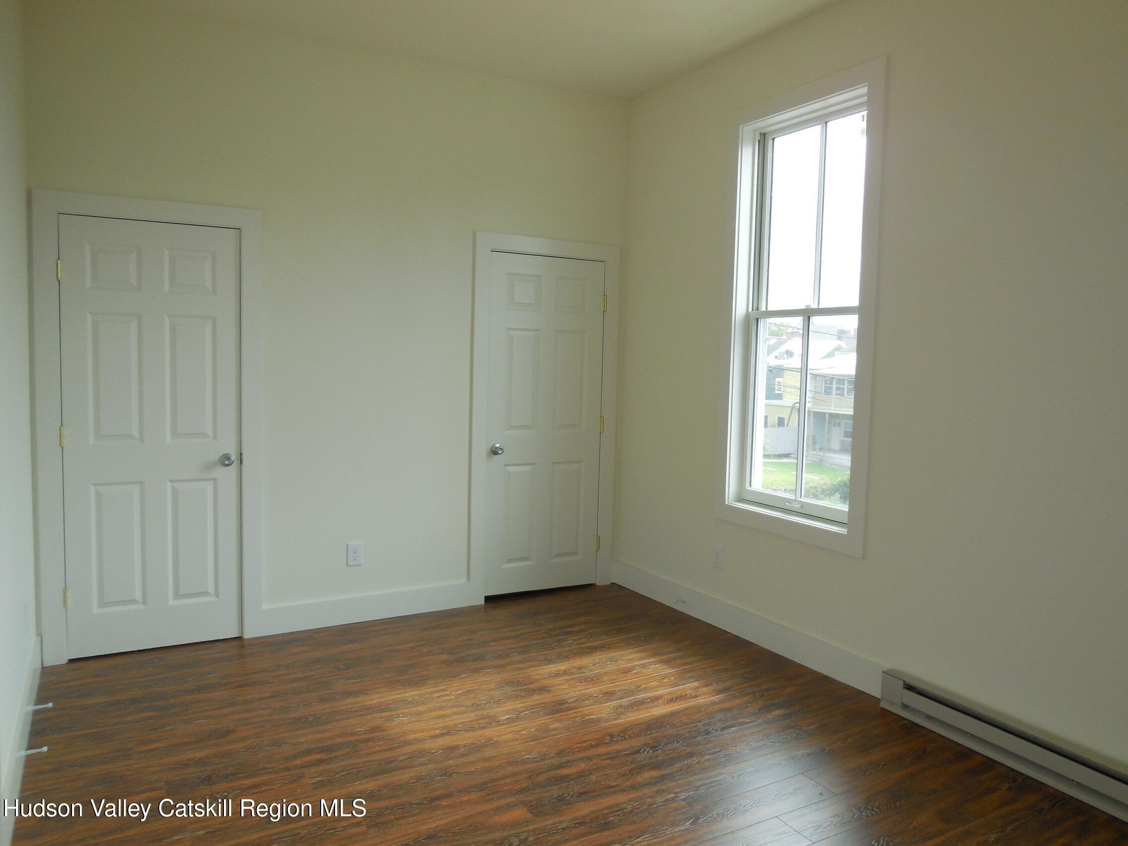 431 Warren Street, Unit 2 Hudson, NY 12534 - Photo 3 of 6 a view of an empty room with wooden floor and a window