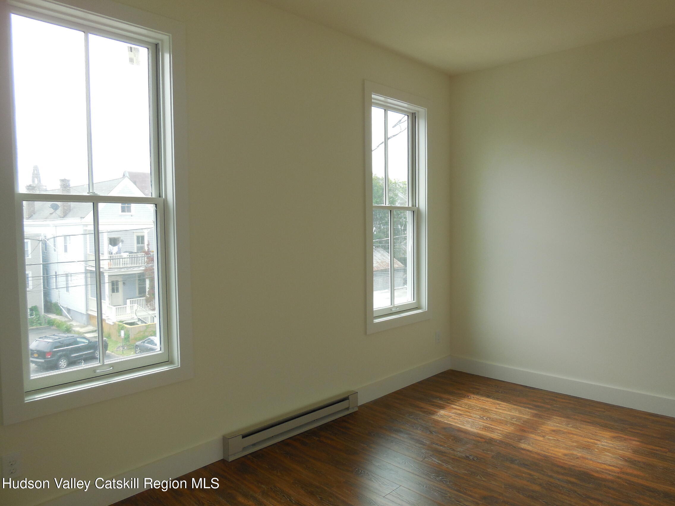 431 Warren Street, Unit 2 Hudson, NY 12534 - Photo 6 of 6 a view of an empty room with wooden floor and a window