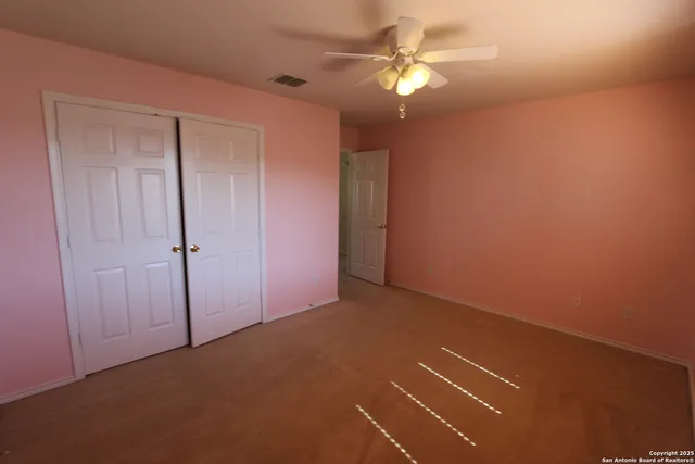 an empty room with a ceiling fan and a window